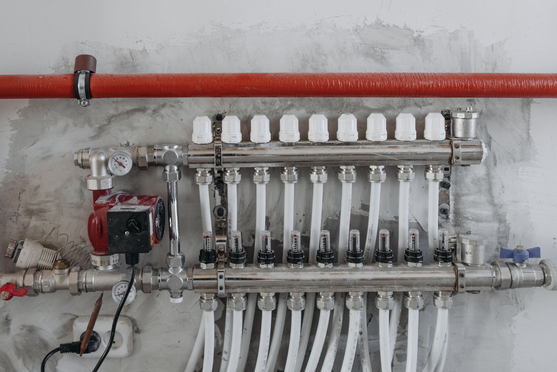 A close-up view of an industrial manifold with pressure gauges and connected steel pipes.