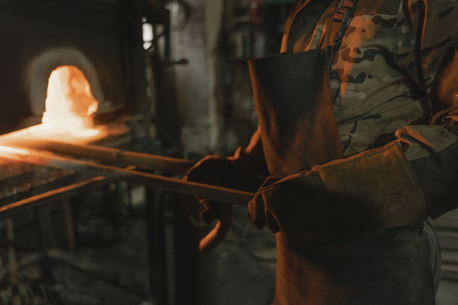 A blacksmith heats metal in a forge, demonstrating traditional metalworking skills.